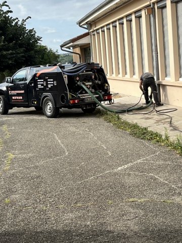 curage de canalisations d'eau pluviales dans une cour d'école à Chuzelles